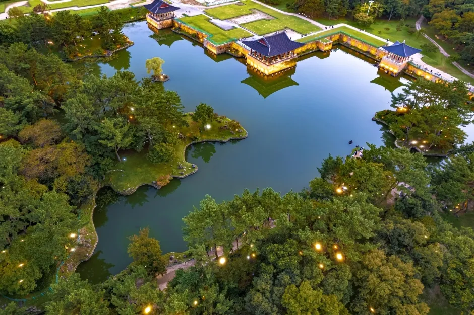 An aerial view at night of Donggung Palace and Wolji Pond in Gyeongju, the lit pavilions reflected in dark water