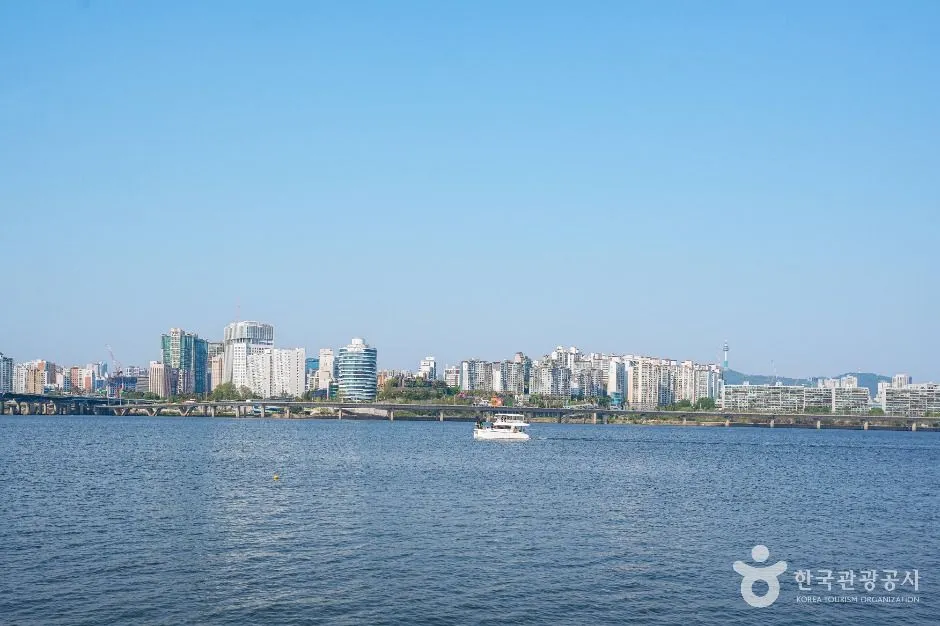 The Han River seen wide and flat with Seoul apartment towers along the far bank