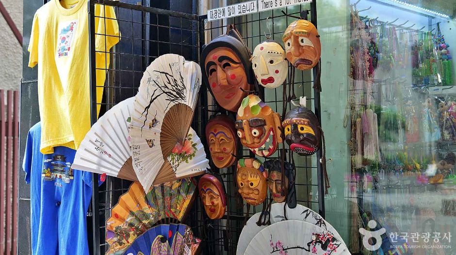 A shop window in Insadong displaying traditional masks, painted fans and T-shirts