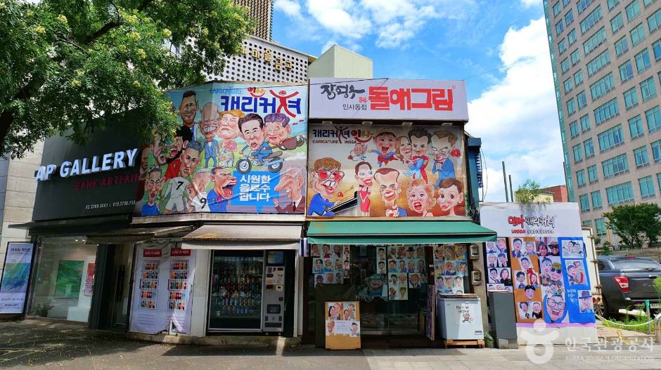 A shopfront in Insadong with several Korean signs above the windows and a gallery sign in English