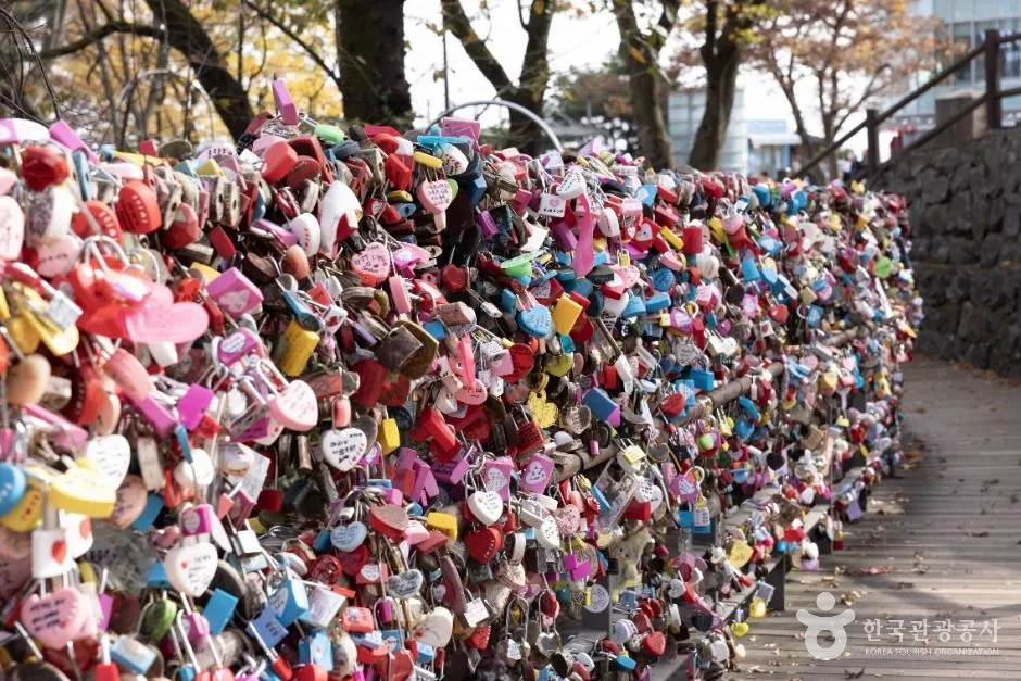 Thousands of coloured padlocks clipped to a fence at the top of Namsan in Seoul